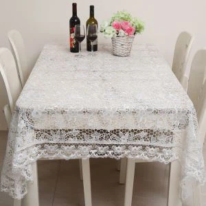 ผ้าปูโต๊ะลูกไม้สีขาวพร้อมดอกไม้ที่จัดขึ้น